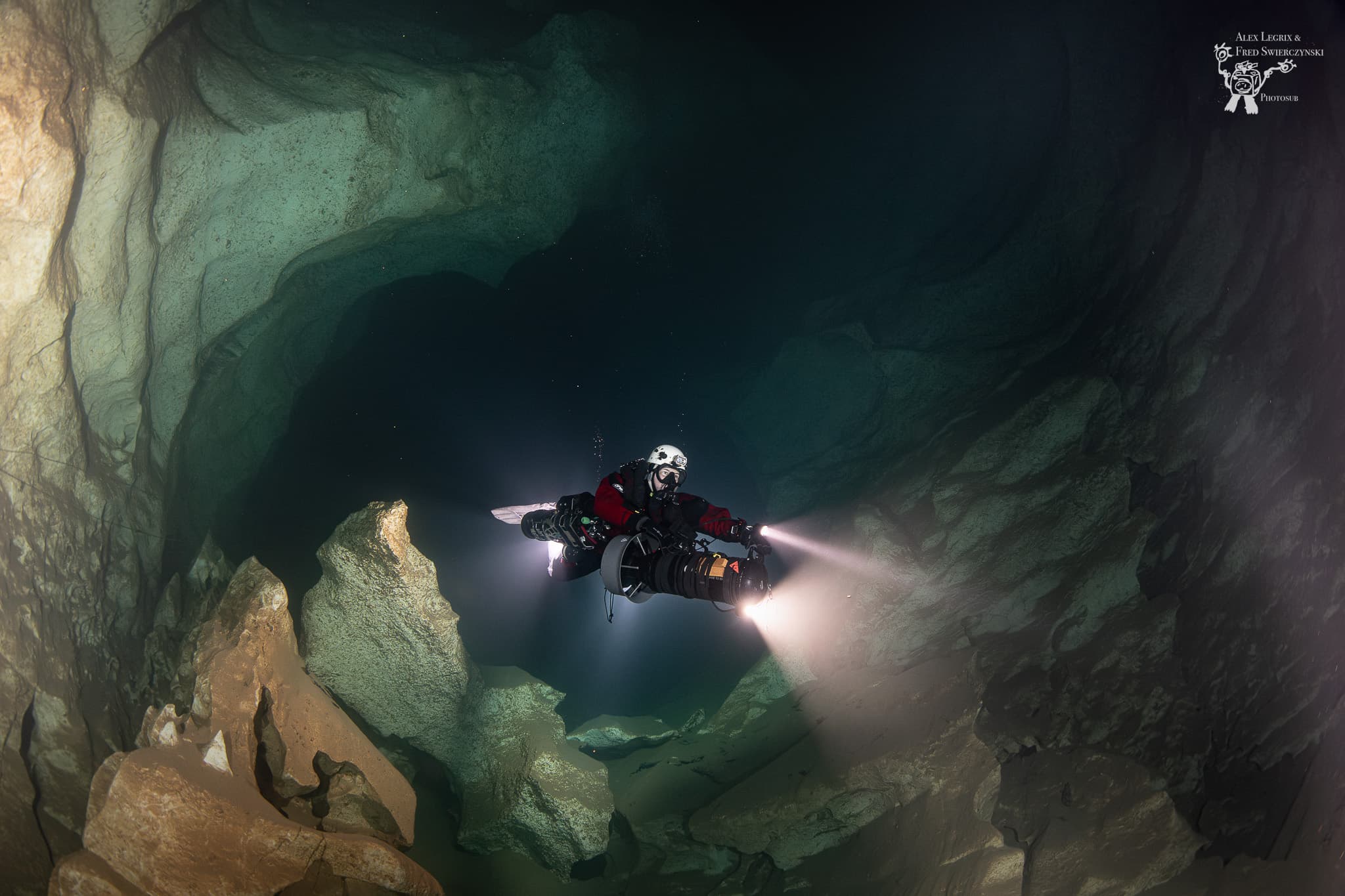 Cave diver with underwater scooter and powerful primary light navigating a dark cave passage